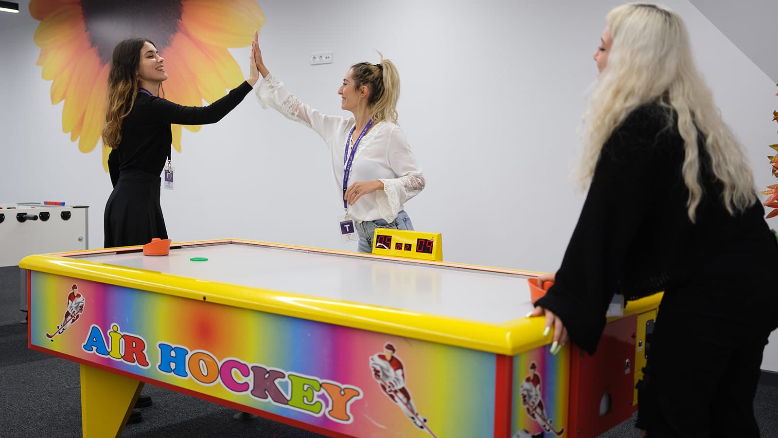 TELUS International team members playing air hockey.