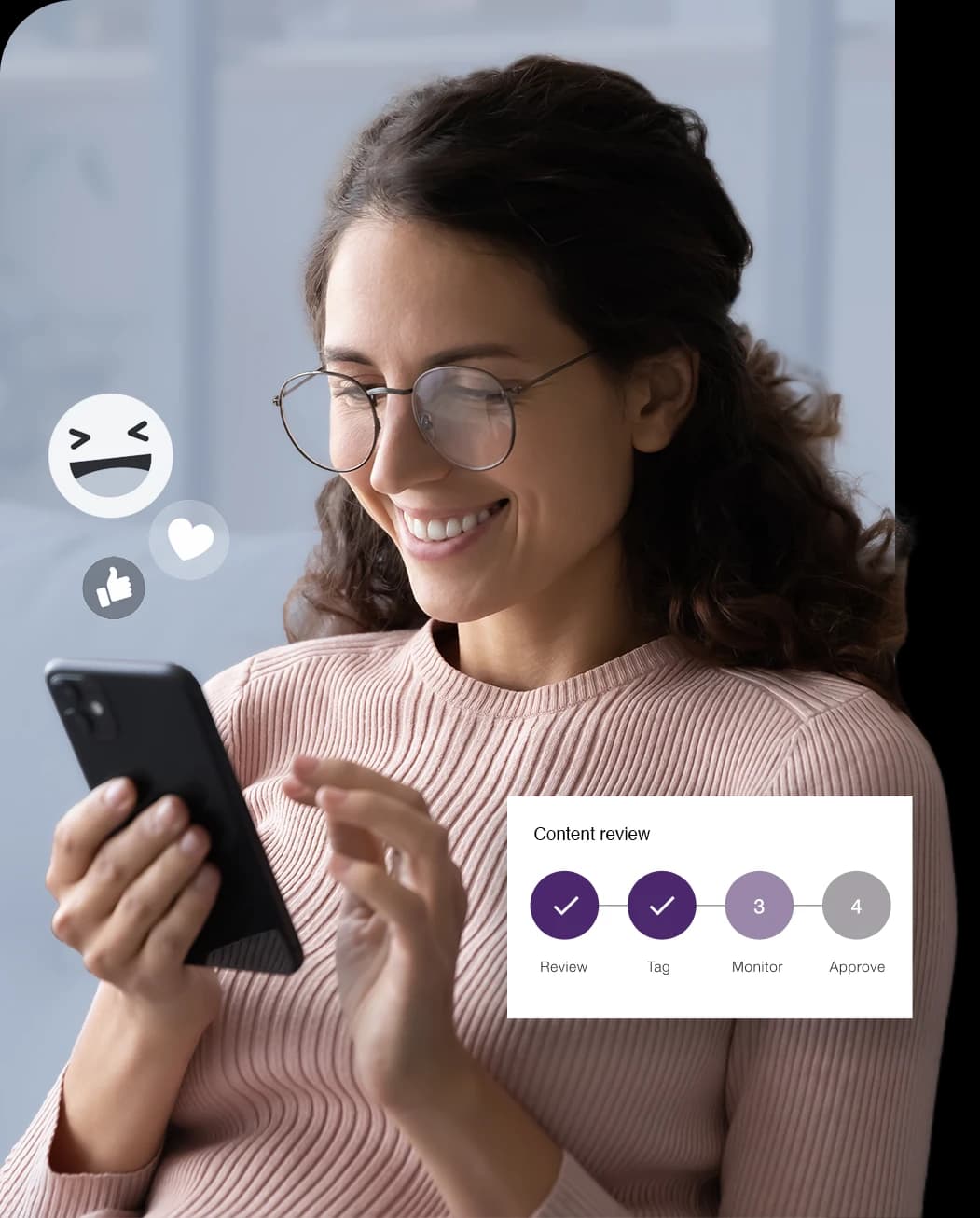 a woman in glasses smiling at a social media post with an overlay of emojis