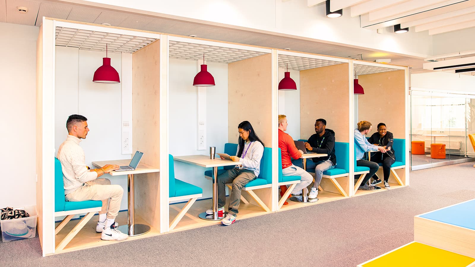 TELUS International employees sitting in cubbies at the Tampere office.