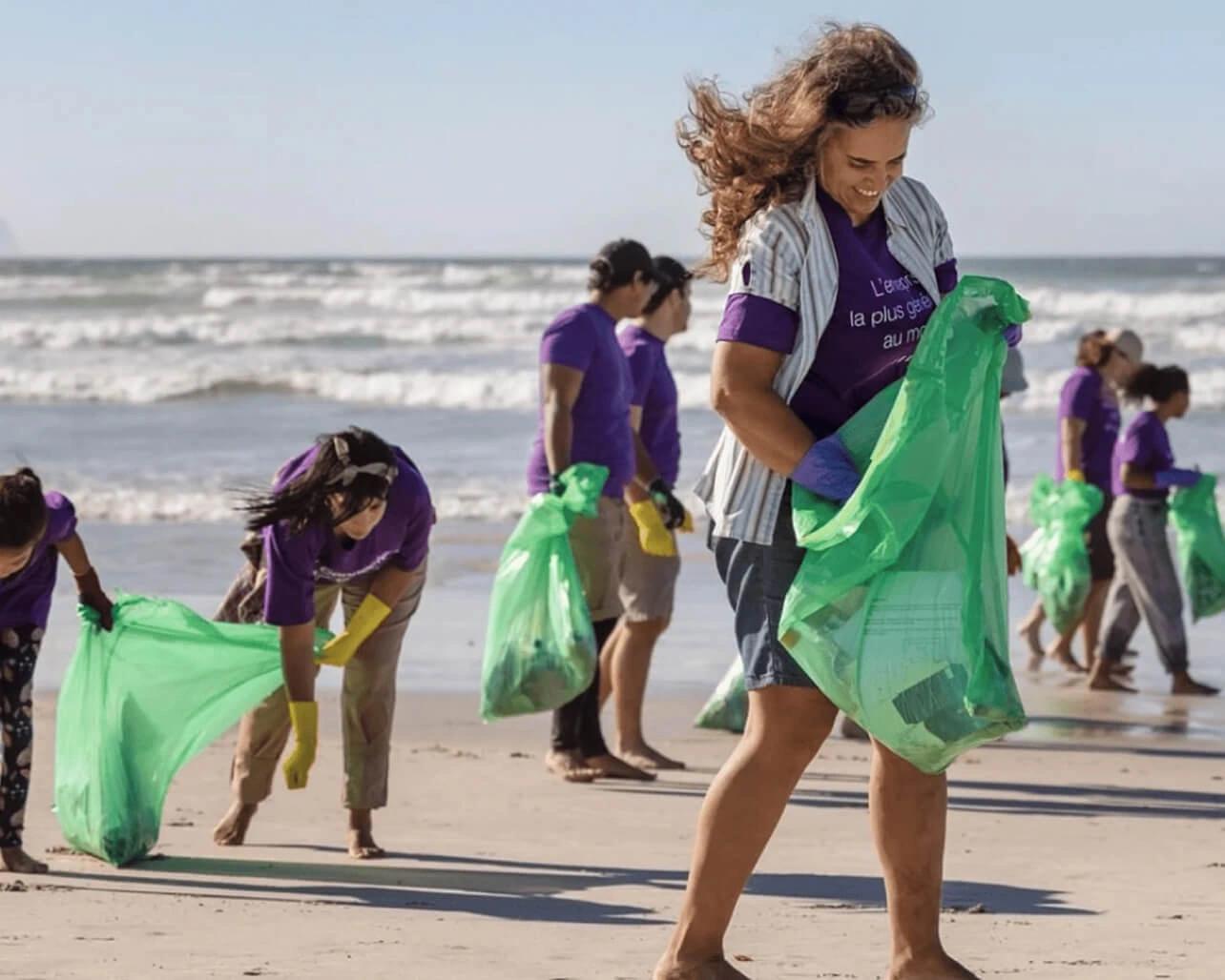 TELUS Digital team members on a beach picking up litter.